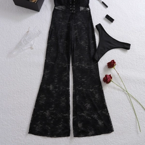 Dettaglio body in pizzo nero con lacci incrociati e pantaloni larghi semitrasparenti eleganti