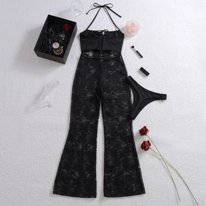 Dettaglio flat lay del set intimo in pizzo nero con nastro ad occhielli e rose