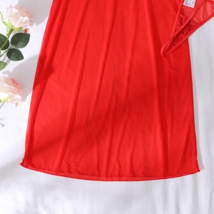 Flat lay of sheer red mesh chemise and thong set with elegant white rose decor