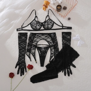 Flat lay of black floral lace lingerie set with garters and stockings on white faux fur