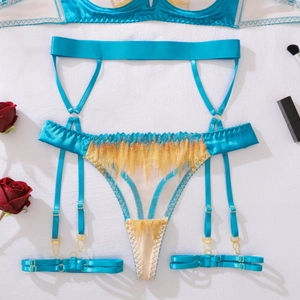 Detailed flat lay of blue satin lingerie set with gold tassels and garter straps