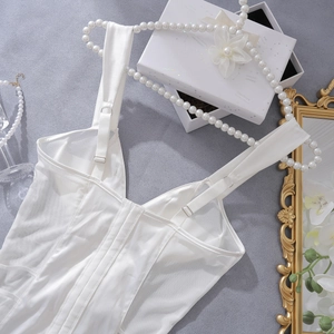 Close-up of white satin corset top with mesh panels and structured boning detail