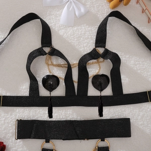 Detail of black lingerie set with golden chains, sequin hearts, and fringe tassels