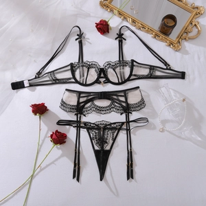 Close-up of black floral lace embroidery and bow detail on sexy three-piece lingerie set