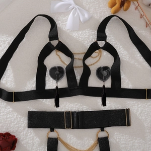 Close-up of black strappy lingerie with gold metal chains, rings and tassel fringe details