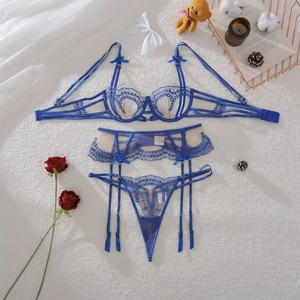 Detailed flat lay of royal blue floral lace lingerie set with bow accents on soft fur