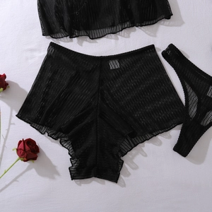 Detailed flat lay of black mesh sheer lingerie set with striped texture and rose accent