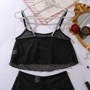 Detail view of black mesh lingerie set with diagonal stripes and elegant flat lay props