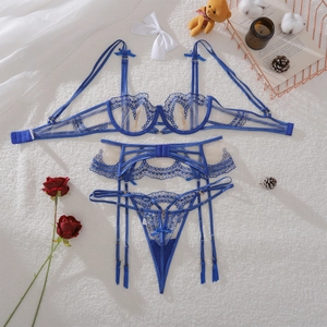 Detailed view of royal blue floral lace lingerie set with bow on white faux fur