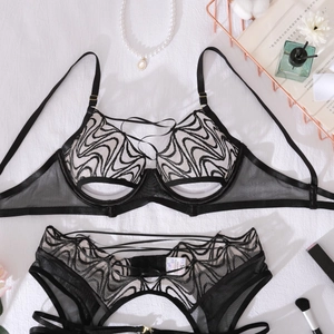 Detail of black embroidered mesh bra with wave patterns and sheer lace texture