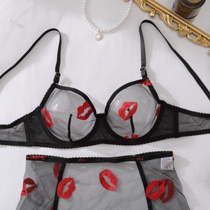 Detailed close-up of sheer mesh lingerie set with red lip embroidery and S size label
