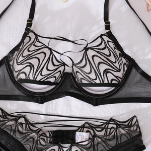 Detail of black lace lingerie set featuring sheer scalloped embroidery and gold hardware