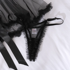 Détail d'un ensemble de lingerie en maille noire transparente avec volants et ruban élégant