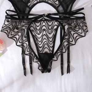 Detail of black lace garter belt with golden metal buckles and mesh embroidery design