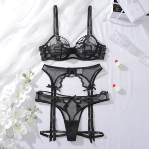 Ensemble lingerie noire avec broderies de cœurs et détails de nœuds sur fond blanc