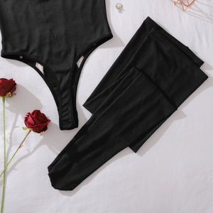 Vue à plat d'un body en maille noire et bas avec décor rose et bijoux