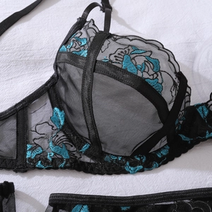 Détail de broderie florale et maille transparente noire sur un soutien-gorge en dentelle