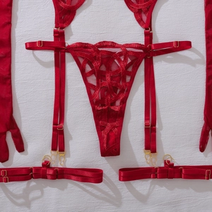 Flat lay of red lace lingerie set featuring thong, garter belt, and sheer gloves detail