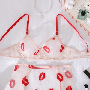 Flat lay of mesh lingerie set with red lip embroidery and scarlet thin straps