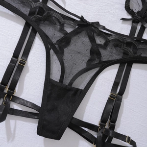 Détail de lingerie en dentelle noire avec mesh, nœuds décoratifs et boucles dorées