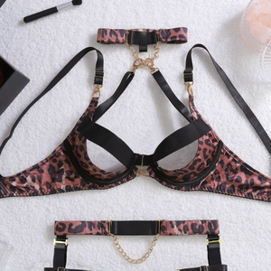 Detail of leopard print lingerie set with metal chains on plush white background