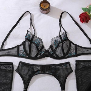 Détail du soutien-gorge en maille noire avec broderie florale turquoise et dentelle
