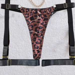 Detail of leopard print satin thong and garter set with gold metal chain accents