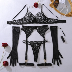 Detail view of black geometric lace lingerie set with mesh gloves and gold metal hardware