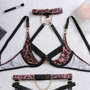 Detail of leopard print lingerie with gold chain links on soft white plush background