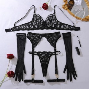 Detailed flat lay of black lace lingerie set with suspender belt and mesh gloves