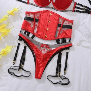 Detailed close-up of red floral embroidery on satin and mesh lace corset lingerie