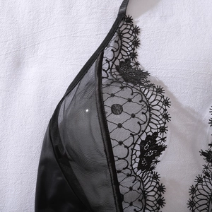 Detail shot of black eyelash lace embroidery and sheer mesh on a sexy lingerie bodysuit