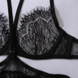Detailansicht schwarzer Wimpernspitze Dessous mit feinem Netzgewebe und Metallschnallen
