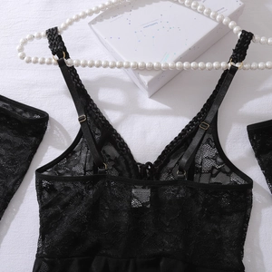 Detail of black lace bodysuit featuring fine floral mesh and golden strap adjusters
