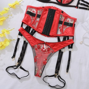 Flat lay detail of red rose embroidery and fishbone corset structure on mesh lingerie