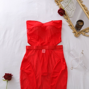 Dettaglio completo di body e gonna in rete rossa con etichetta e accessori eleganti