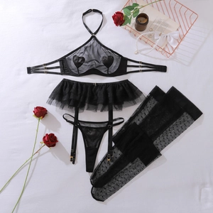 Flat lay of black lace mesh lingerie set with heart patches, stockings and roses
