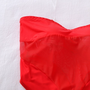 Dettaglio di lingerie patchwork in rete rossa con bordi a conchiglia e trama traspirante