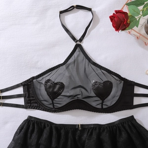 Flat lay of black mesh lingerie set with heart patches and halter neck straps