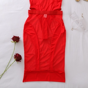 Dettaglio di body rosso in mesh trasparente con design cut-out e collana di perle su tessuto