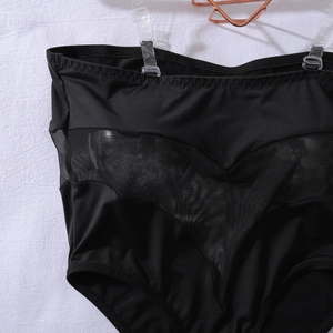Dettaglio di body nero a vita alta in mesh con spalline trasparenti e rimovibili