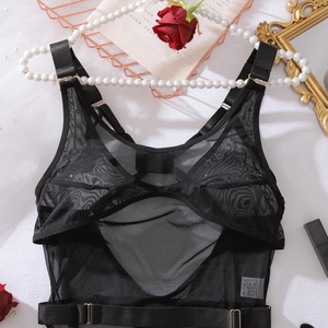 Détail d'un body en maille noire transparente avec bretelles et boucles décoratives