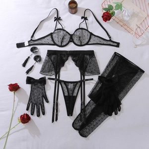 Dettaglio del set lingerie in rete a pois neri con finiture in pizzo e accessori