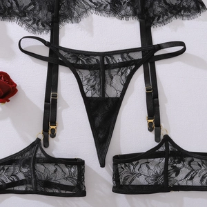Détail du motif en dentelle florale et boucles dorées sur un ensemble de lingerie corset noir