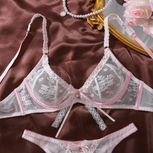 Détail d'un ensemble lingerie en dentelle blanche avec bretelles en satin rose