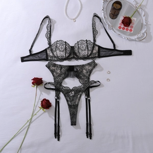 Detail of black floral embroidery on sheer lace lingerie set with garters and thong
