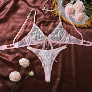 Détails à plat d'un ensemble de lingerie en dentelle rose avec bretelles florales sur satin