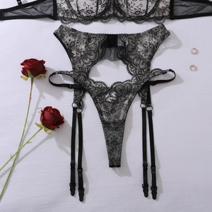 Detail of floral embroidery on black lace garter belt with metallic buckles and roses