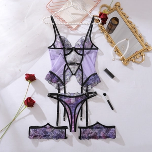 Set lingerie in pizzo viola con reggicalze e decorazioni floreali sul fondo