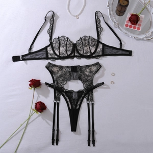 Detailed flat lay of black floral lace lingerie set with garters and rose decorations
